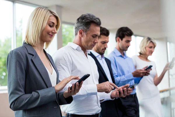 Üzleti vezetők digitális tábla és a mobil telefon használata — Stock Fotó