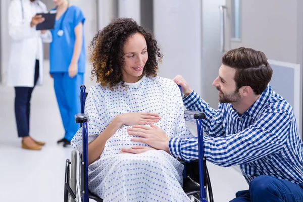 Man tröstande gravid kvinna i korridor — Stockfoto