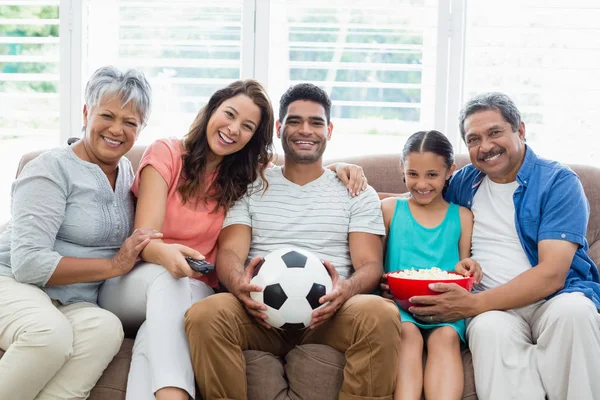 Щаслива багатоповерхова сім'я дивиться футбольний матч на телебаченні у вітальні — стокове фото