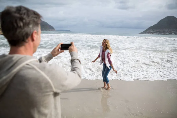 Mature man clicking a picture of woman — Stock Photo, Image