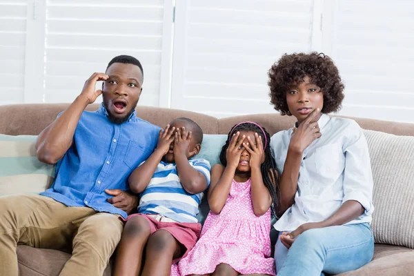 Familia y niños viendo televisión mientras comen palomitas de maíz en la sala de estar en casa — Foto de Stock