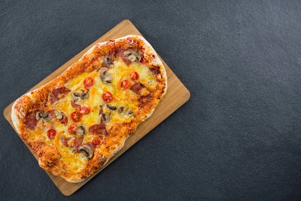 Italienische Pizza auf einem Schneidebrett serviert — Stockfoto