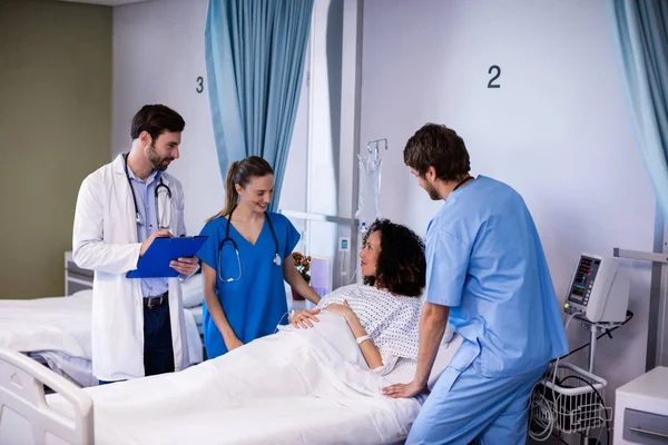 Equipe de médicos interagindo com a mulher grávida — Fotografia de Stock