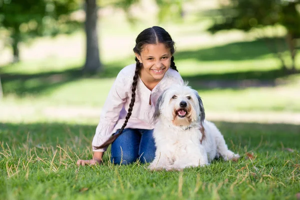 Retrato de niña sonriente jugando con su perro mascota — Foto de Stock