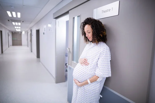 Беременная женщина стоит в коридоре — стоковое фото