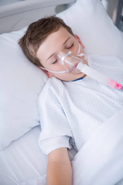 Pojke patienten bär syre mask liggande på sjukhussäng — Stockfoto