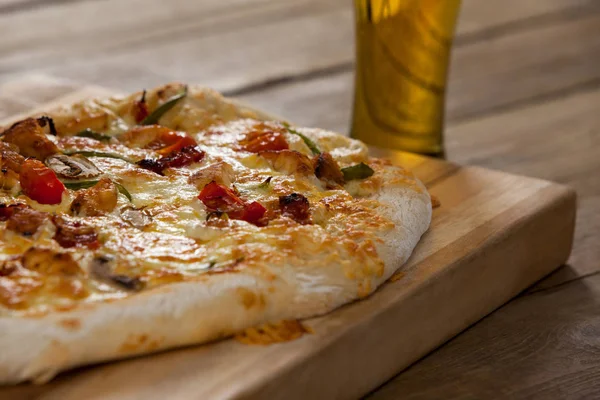 Deliciosa pizza servida sobre tabla de madera con un vaso de cerveza — Foto de Stock