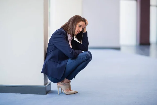 Inquiète femme d'affaires accroupi sur le sol — Photo