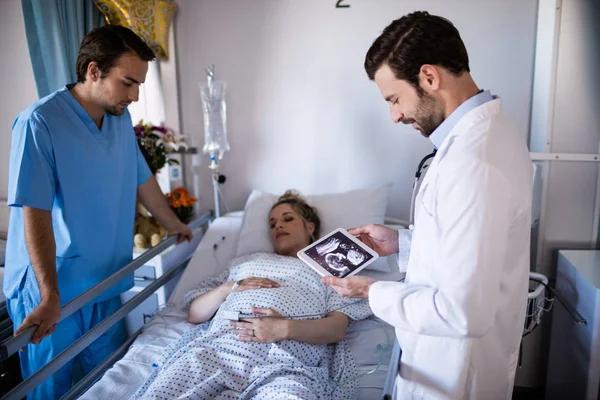Médico masculino a olhar para o relatório de ultrassonografia num comprimido digital — Fotografia de Stock