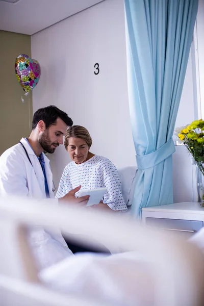 Médico varón que interactúa con una paciente mayor femenina en la sala — Foto de Stock