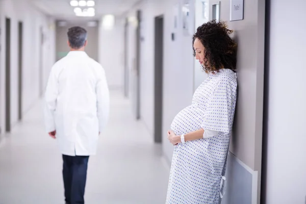 Pregnant woman standing in corridor — Stock Photo, Image