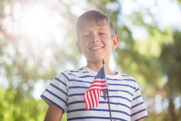 Niño sosteniendo pequeña bandera americana — Foto de Stock