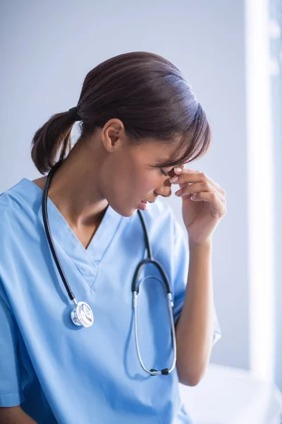 Médico tenso sentado no corredor — Fotografia de Stock