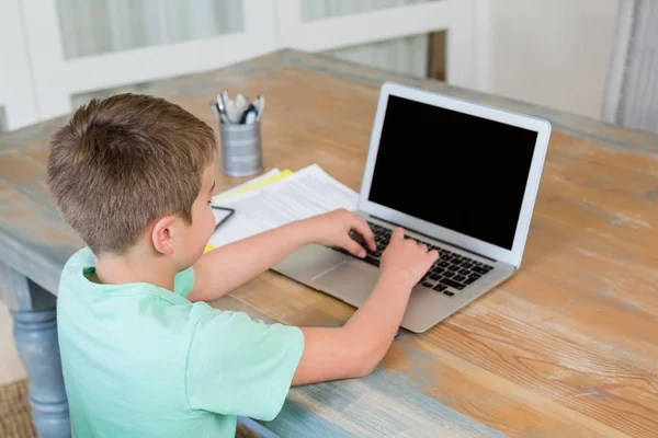 Pojke med laptop på skrivbord — Stockfoto