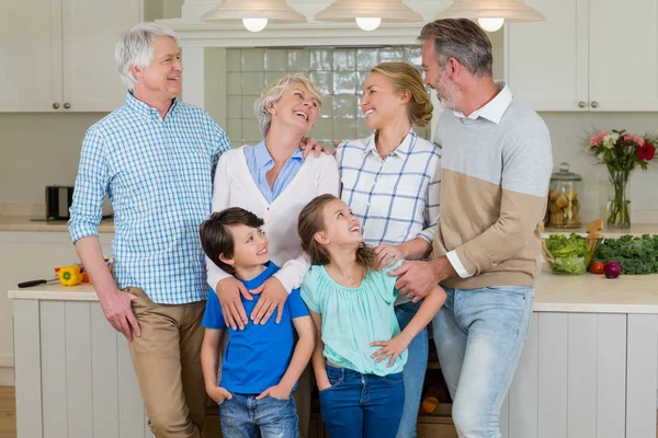 Família feliz interagindo uns com os outros na cozinha — Fotografia de Stock