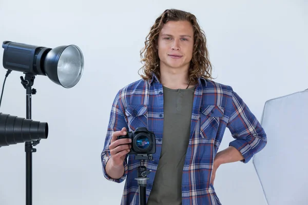 Fotograf drží fotoaparát ve fotoateliéru — Stock fotografie