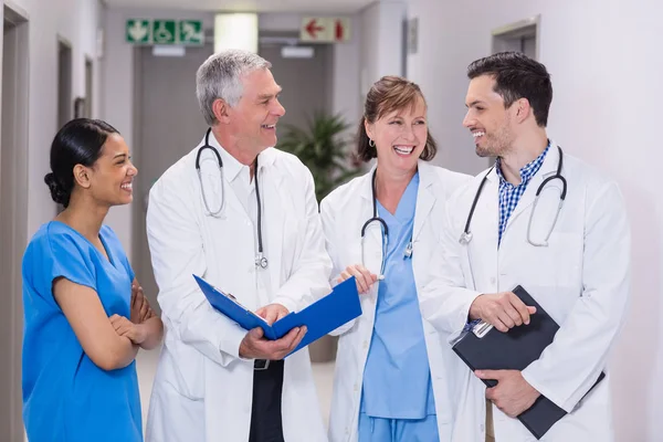 Enfermeira sorridente e médicos discutindo sobre prancheta — Fotografia de Stock