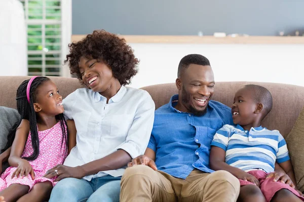 Ouders en kinderen interactie zittend op de Bank in de woonkamer — Stockfoto