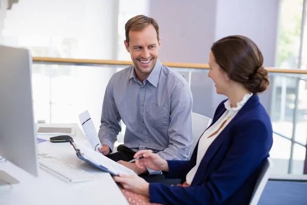 Businesswoman working at desk with colleague — Stock Photo, Image