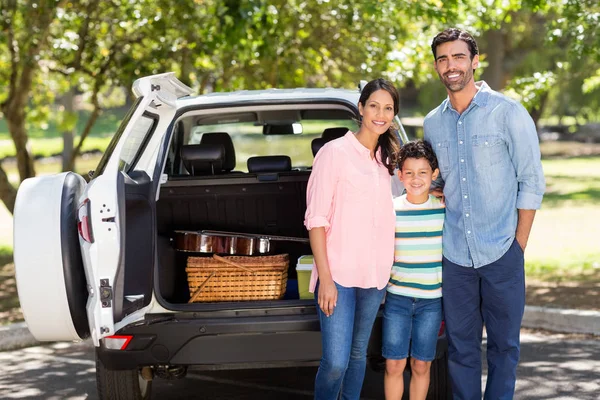 Famiglia felice su un picnic in piedi accanto alla loro auto — Foto Stock