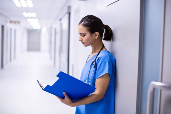 Médica mulher ler relatórios no corredor — Fotografia de Stock