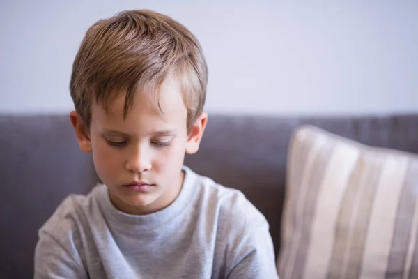 Rozrušený chlapec sedí na pohovce v chodbě — Stock fotografie