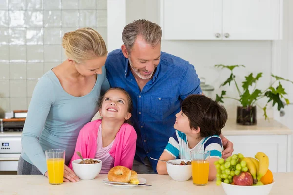 Lykkelig familie, der spiser morgenmad i køkkenet - Stock-foto