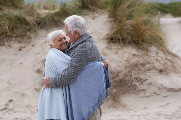 Seniorenpaar in Schal gehüllt am Strand — Stockfoto