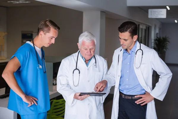 Doctors discussing over clipboard — Stock Photo, Image