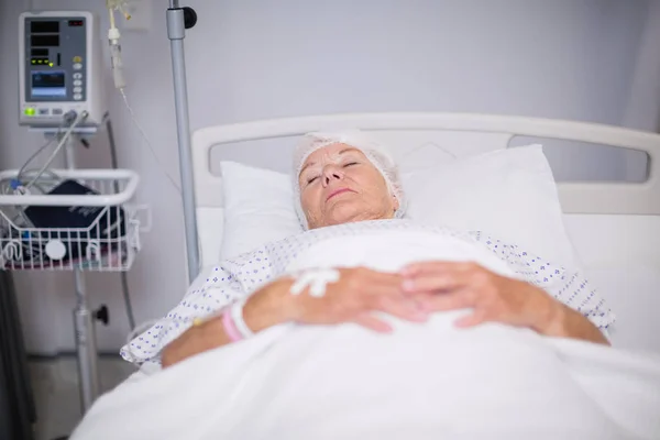 Paciente sênior usando máscara de oxigênio deitado na cama — Fotografia de Stock