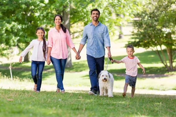 Familj njuter tillsammans med sin hund i parken — Stockfoto