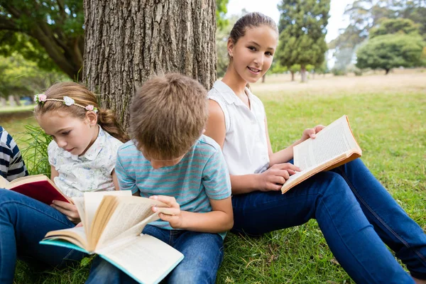 Niños leyendo libro en el parque — Foto de Stock