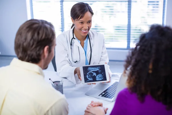 Paar echografie van de baby's kijken op artsen digitale tablet — Stockfoto