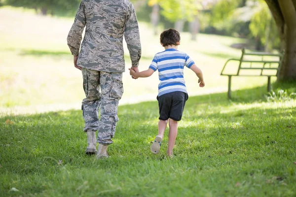 Soldado do exército caminhando com menino no parque — Fotografia de Stock