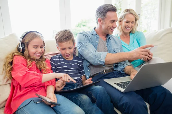 Genitori e bambini che utilizzano tablet, telefoni cellulari e laptop digitali — Foto Stock