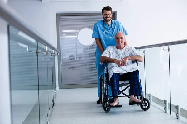 Docteur poussant un patient en fauteuil roulant — Photo