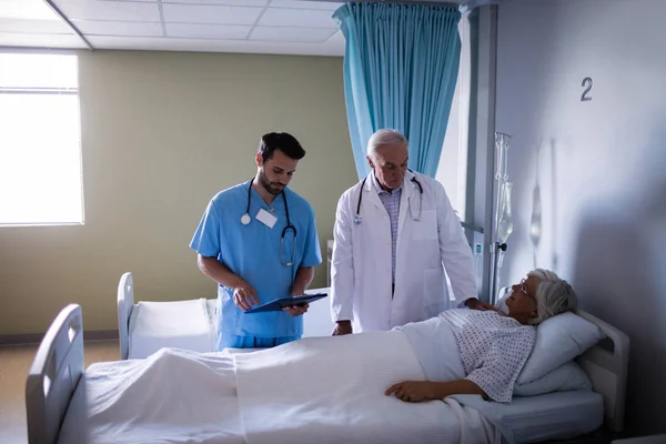 Läkare undersöka senior patient i församlingen — Stockfoto