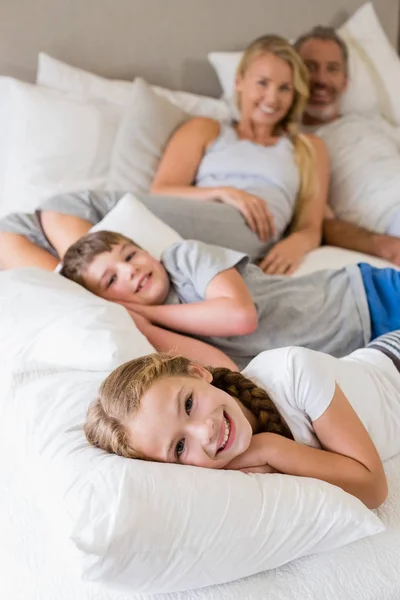 Pais e crianças relaxando na cama no quarto — Fotografia de Stock