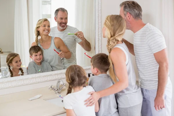 Ouders en kinderen tandenpoetsen in de badkamer — Stockfoto