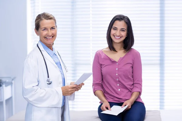 Leende läkare och patient på klinik — Stockfoto