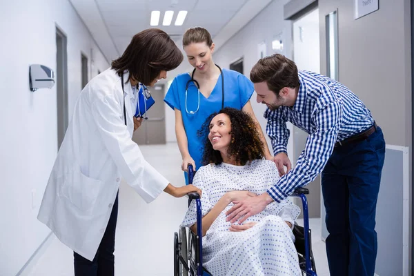 Homem e médicos consolando mulher grávida no corredor — Fotografia de Stock