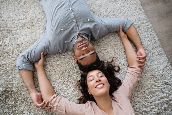 Pár na dovolené na koberec v obývacím pokoji — Stock fotografie