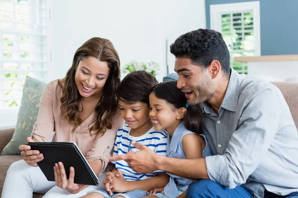 Parents et enfants utilisant une tablette numérique dans le salon — Photo