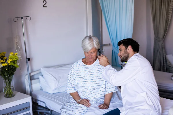 Médico examinando pacientes orelha com otoscópio — Fotografia de Stock