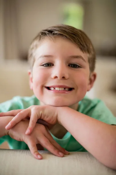 Sonriente niño sentado en el sofá en la sala de estar —  Fotos de Stock