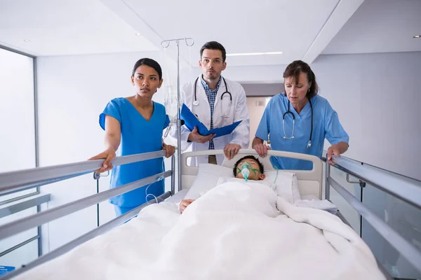 Lekarze badając pacjenta w korytarzu — Zdjęcie stockowe