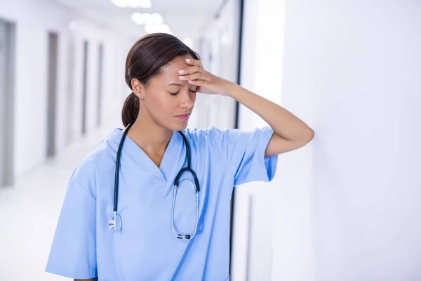 Médica tensa em pé no corredor — Fotografia de Stock