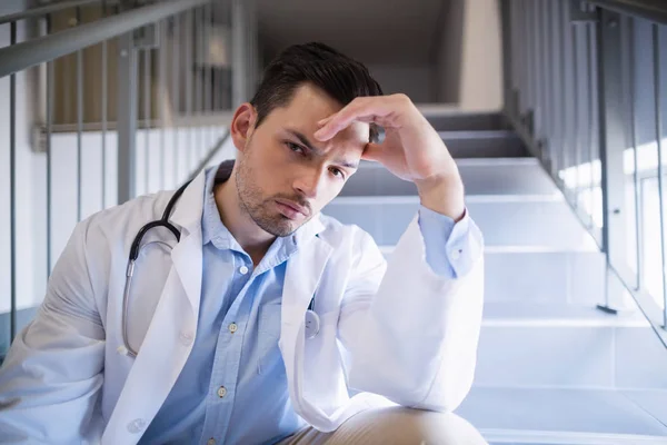 Retrato de médico atencioso sentado na escada — Fotografia de Stock