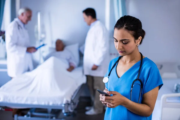 Médica mulher falando em um telefone celular na enfermaria — Fotografia de Stock