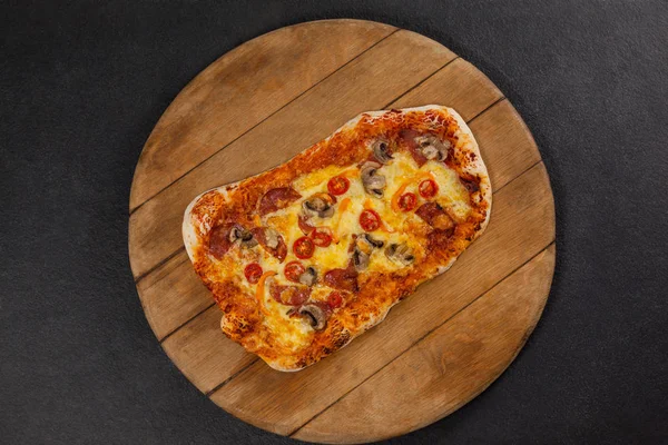 Delicious italian pizza served on wooden board — Stock Photo, Image